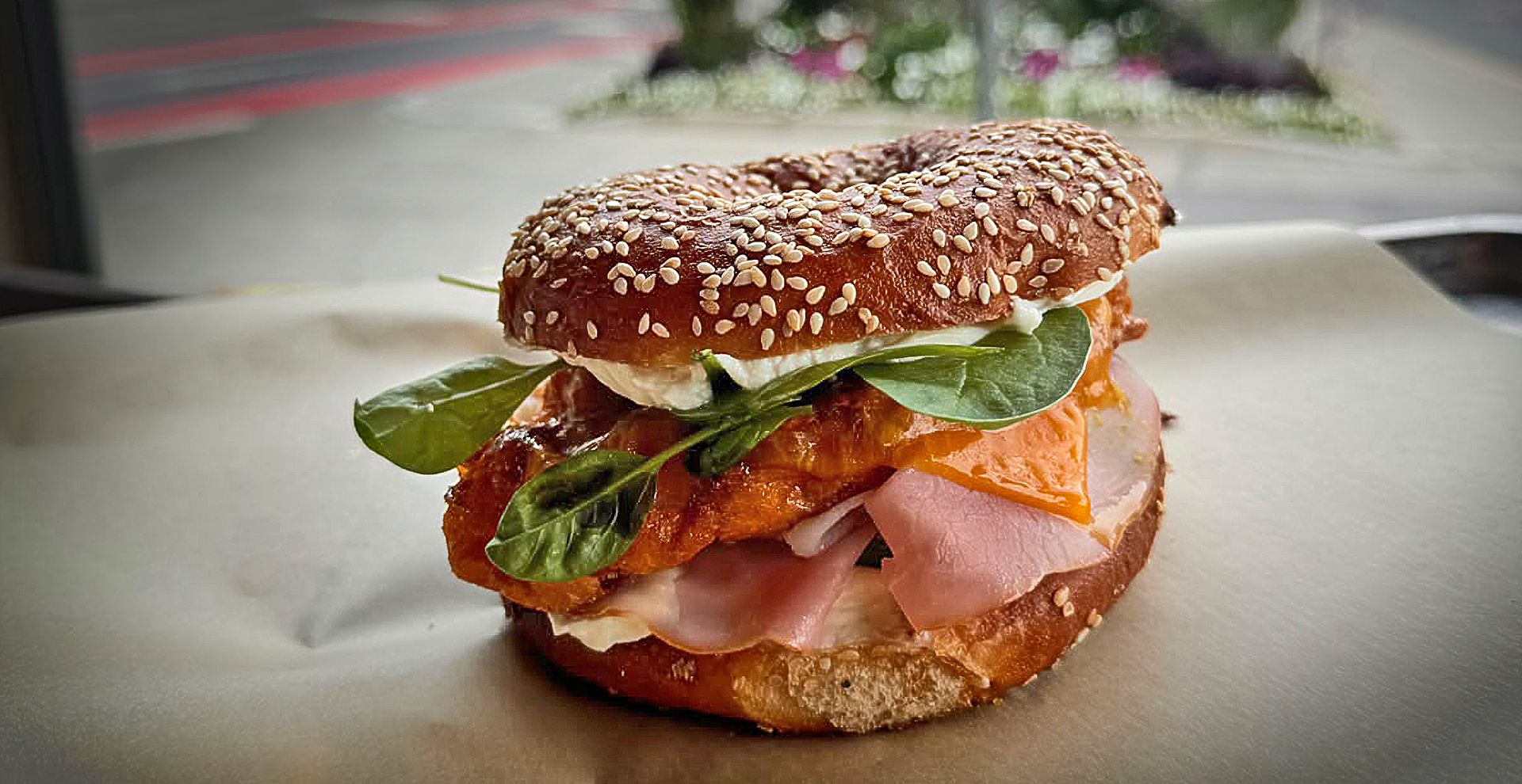 Sesam-Bagel mit Schinken, Käse, Frischkäse und Babyspinat beim Franz